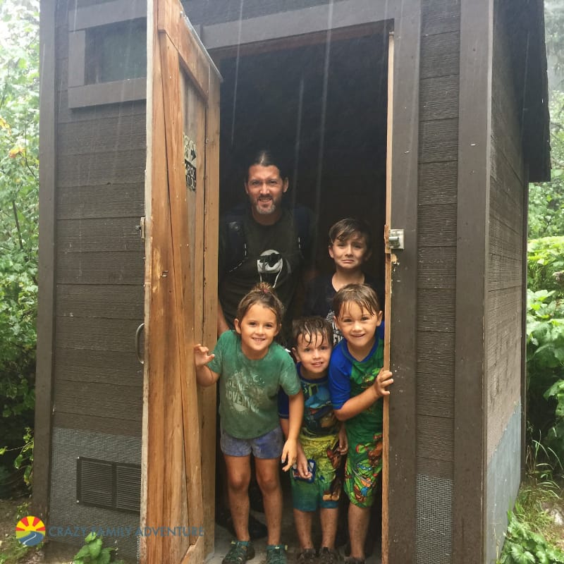 Taking cover from a down pour in an outhouse after hiking to Avalanche Lake