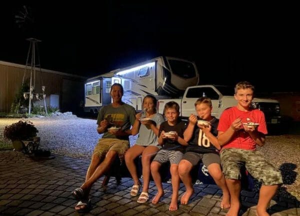 A family eating ice cream sitting in front of an RV, Boondocks Welcome