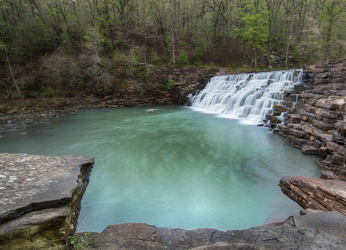 Shows a beautiful waterfall at Devils Den State Park in Arkansas