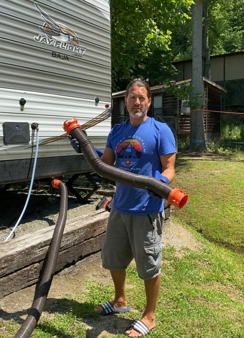 Man holding up a sewer hose