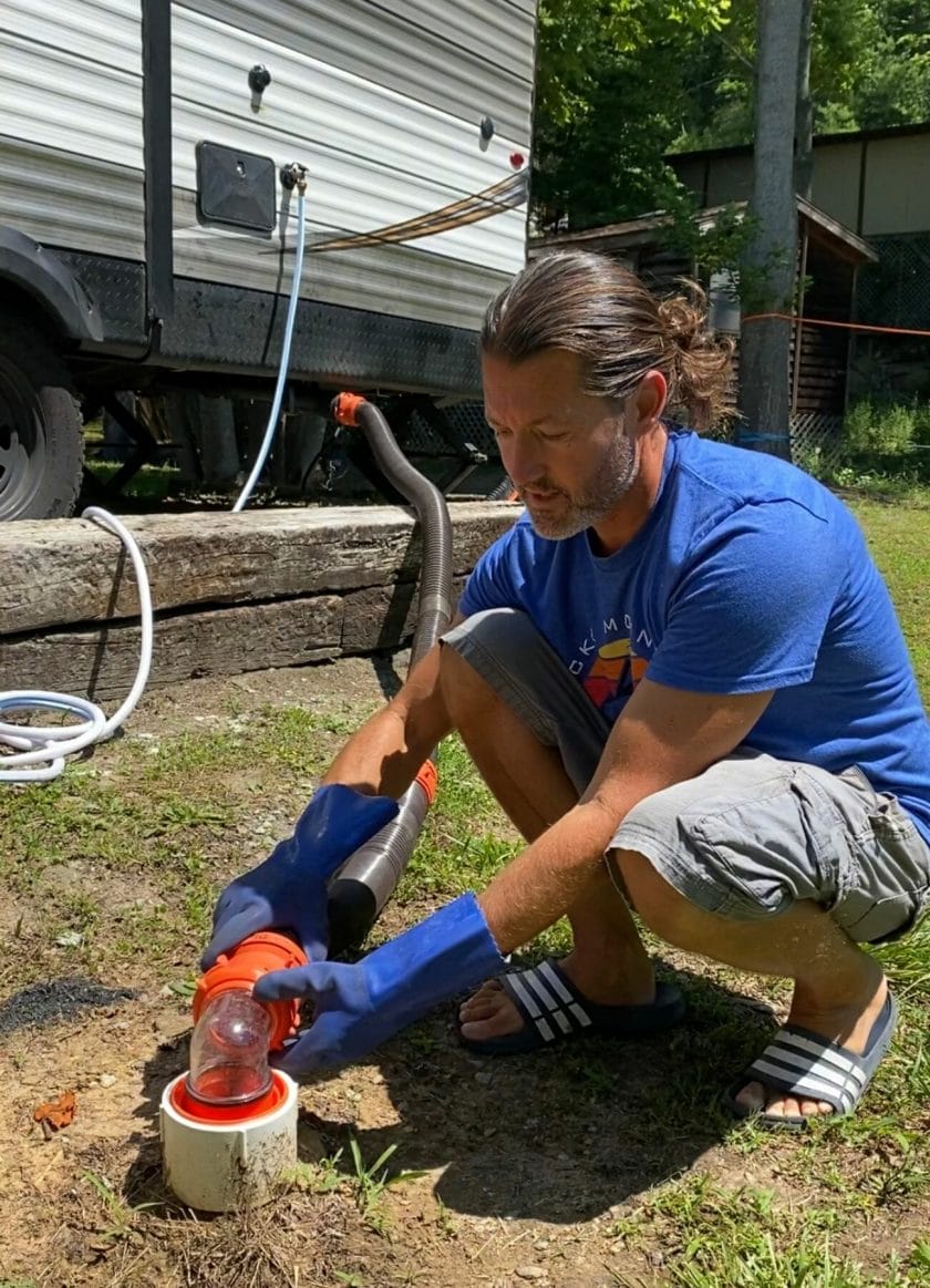 Sewer hose connections and accessories. Picture of man attaching the sewer hose.