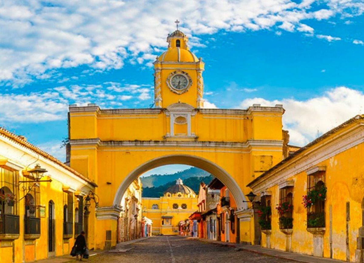 Shows the famous arch in Antigua Guatemala overlooking ancient cobblestone streets
