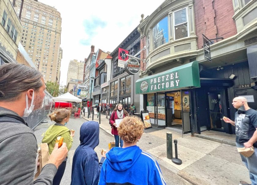 Shows a family on a food tour outside of the Philly Pretzel Factory, fun things to do in Philadelphia with kids