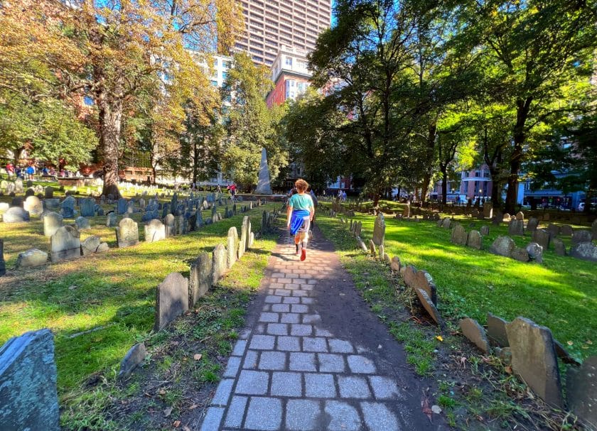 Picture of a boy walking through the tombstones at Granary Burying Ground in Boston, MA Things to do in Boston with Kids