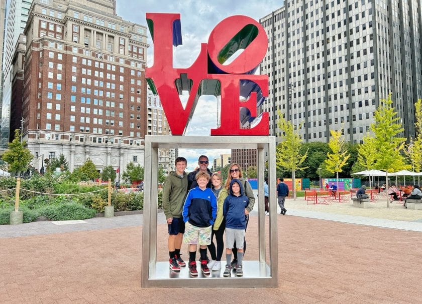 Family standing under the Love Sign in Philly.Things to do in Philadelphia with kids. 