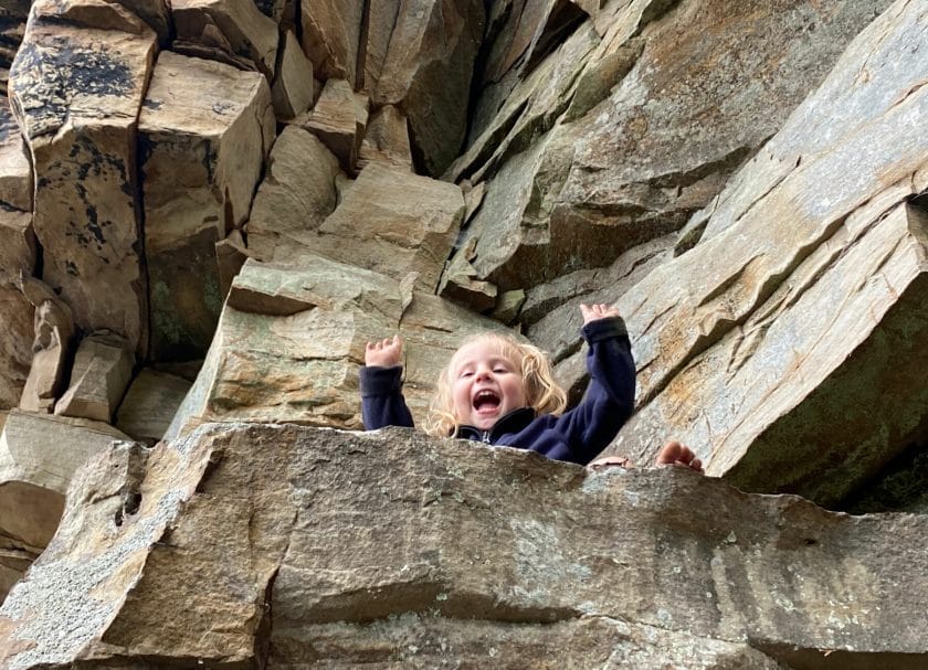 A child playing on rocks along the Castle Rock Trail, things to do New River Gorge National Park.