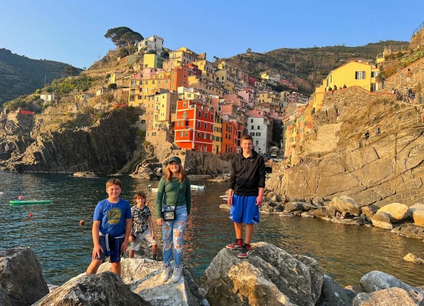 Kids standing in front of a town in Cinque Terre.