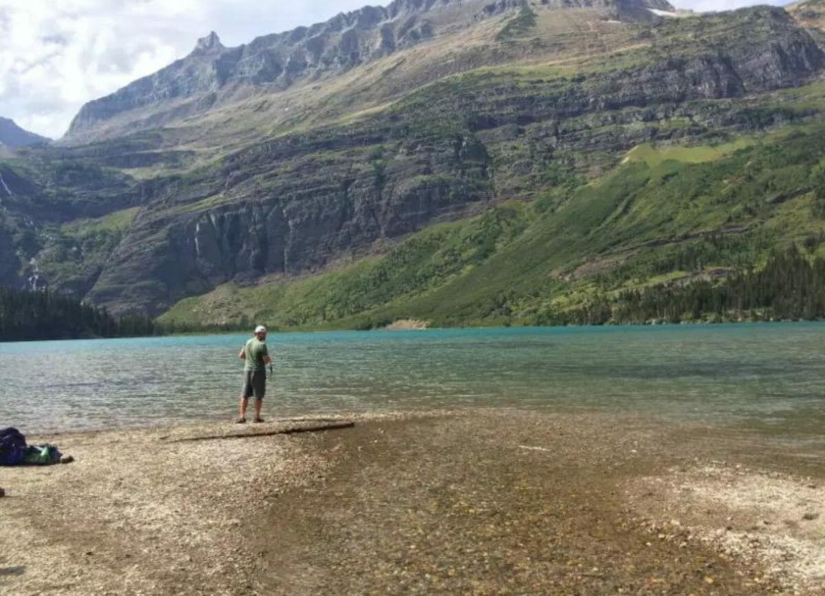 A man standing next to Grinnell Lake