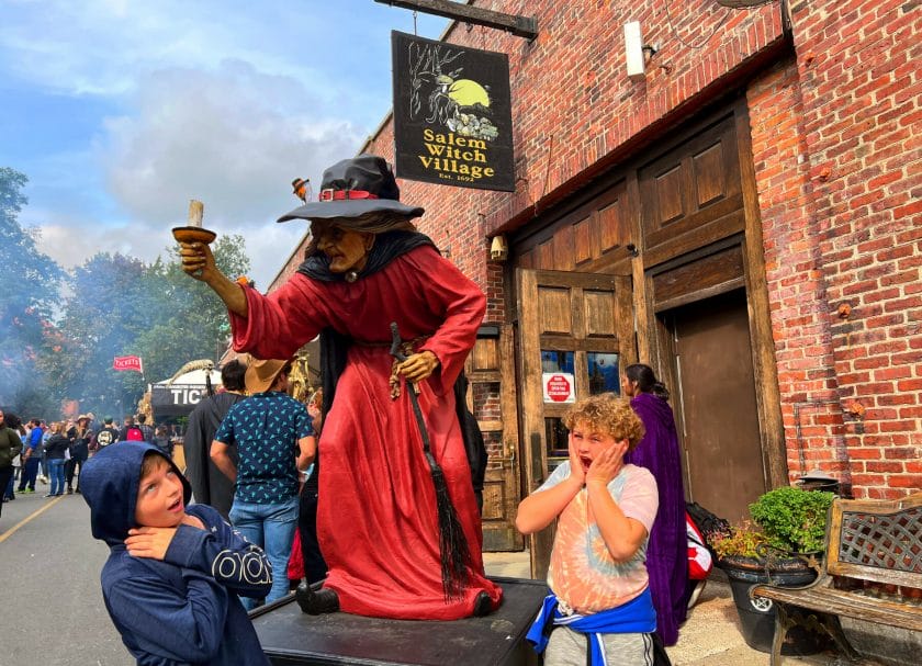 Kids posing acting scared by a statue of a witch in Salem, MA, Things to do in Boston with Kids