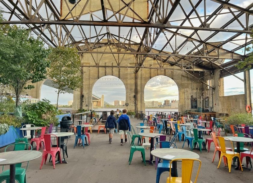 Shows 2 kids walking among the colorful chairs at Cherry Street Pier, Things to do in Philadelphia with kids.