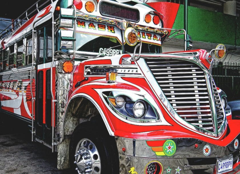 Shows a close up view of an old US school bus that has been repainted in bright red with lots of chrome, Things to do in Antigua Guatemala