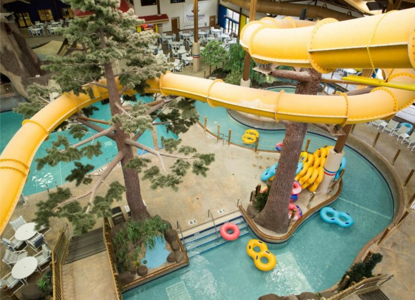 Shows a downward view of the large yellow water slide over the pool, indoor water parks Wisconsin