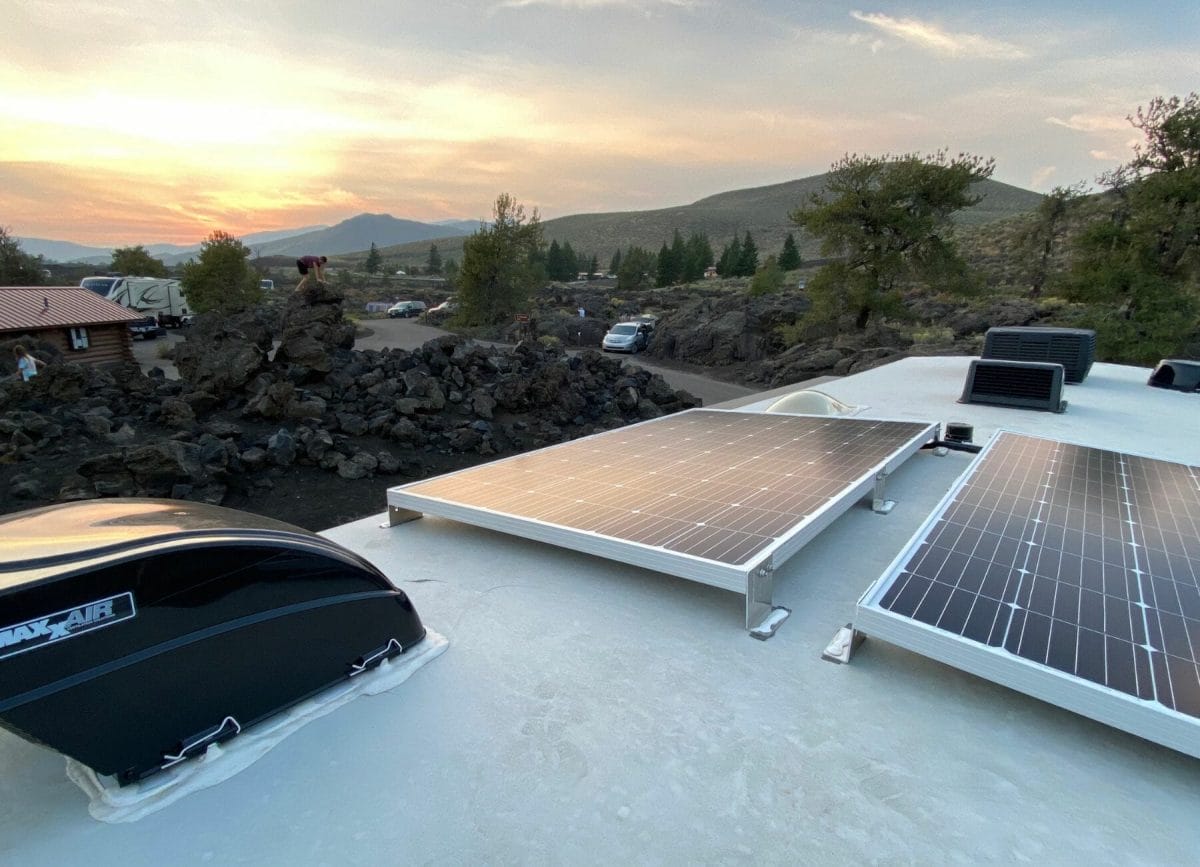 Shows a close up view of an RV roof with solar panels and a sunset in the distance, Best RV Roof Sealants