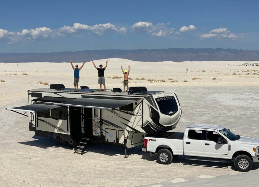 Shows 3 people standing on an RV roof, with a white desert in the background, Best RV Roof Sealants