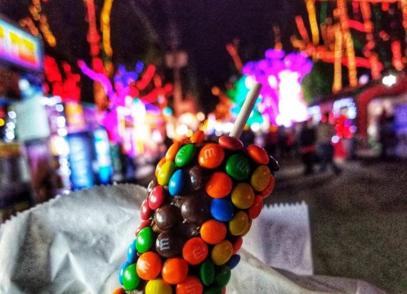 Shows candy on a stick with the boardwalk in the background, Santa's Enchanted Village