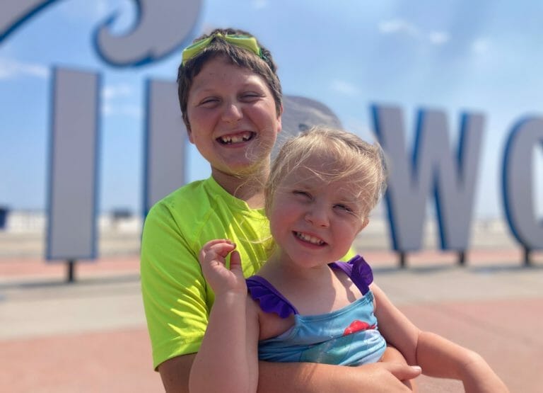 The picture shows 2 kids on the boardwalk in Cape May