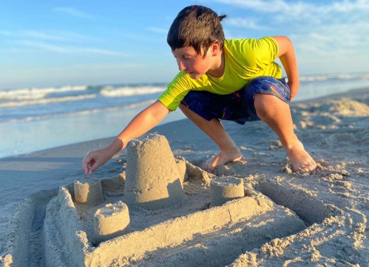 Shows a little boy building a sand castle at the beach, Things to do in Cape May New Jersey