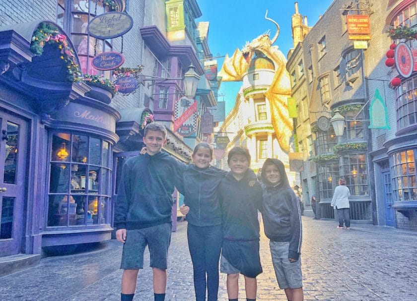 Shows 4 kids standing in Diagon Alley, Harry Potter World Rides