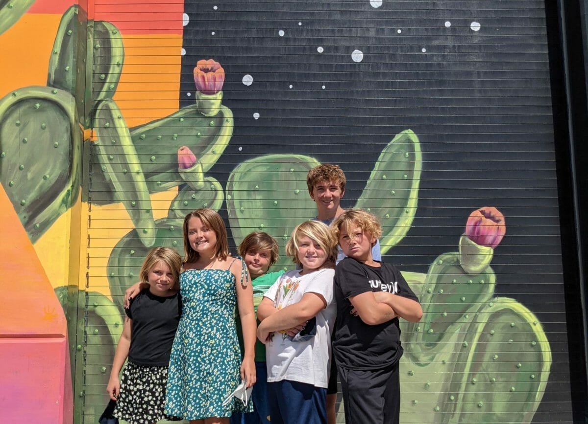 Shows 6 kids posing in front of art at Meow Wolf Las Vegas, Meow Wolf Review