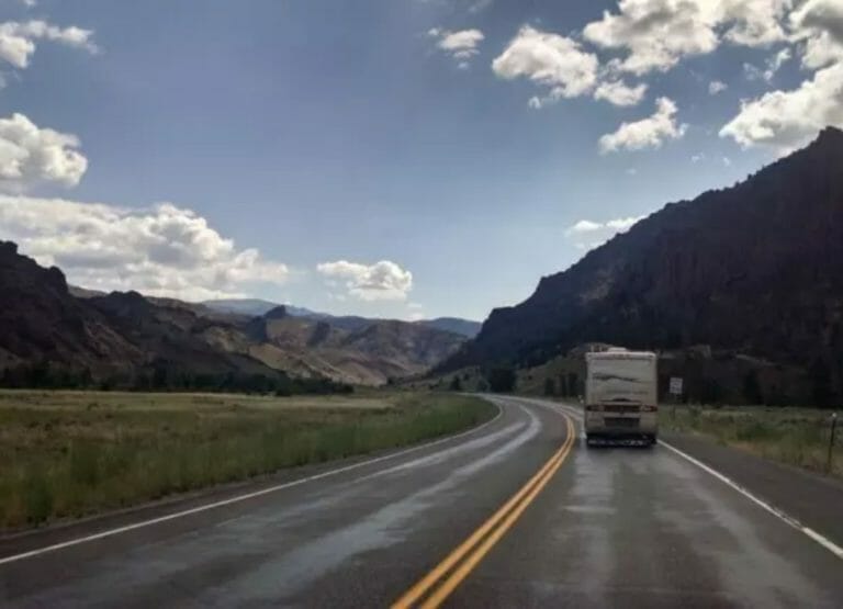Shows an RV heading down the road, Road Trip tips for Families