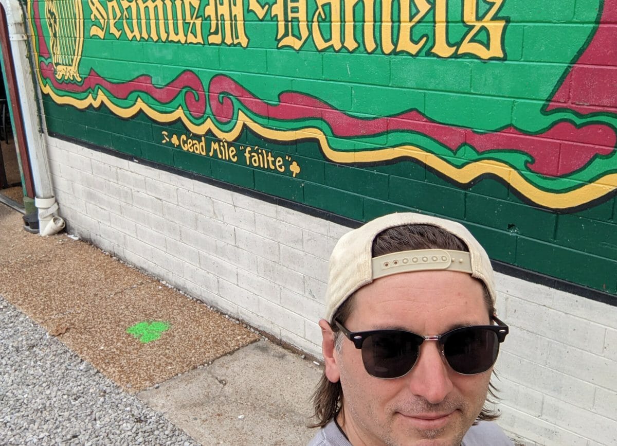 Shows a man in front of the painted sign for Seamus McDonald in St Louis, St Louis Family Vacation Ideas