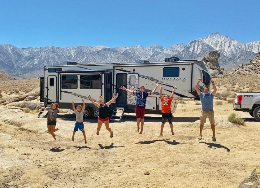 Our family of 6 jumping in Alabama Hills with our RV in the background. 