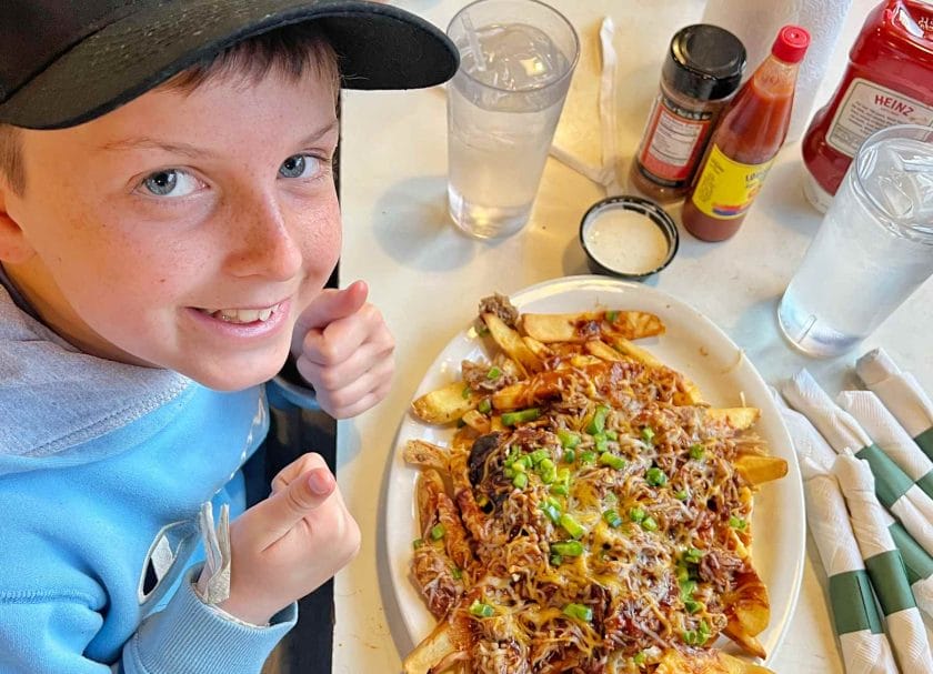 Knox with his plate of fries covered in pulled pork.