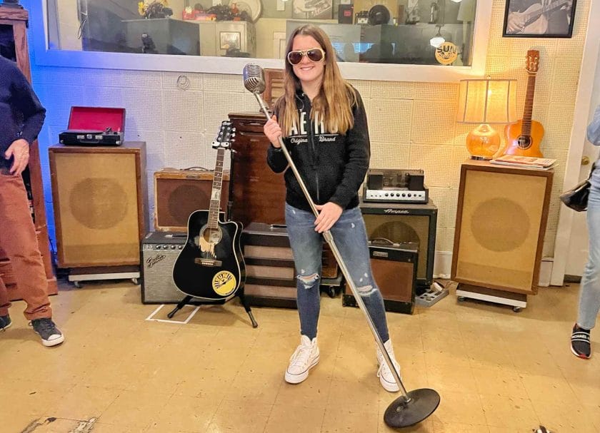 Melia singing in the microphone at Sun Studio. 