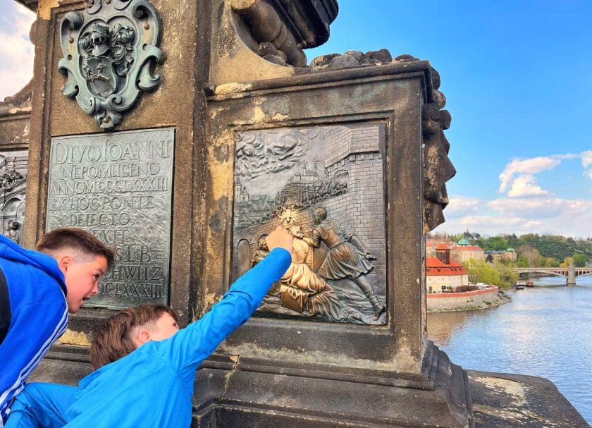 Kids rubbing the statue for luck on Charles Bridge