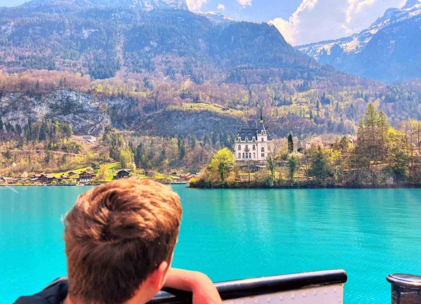 Carson looking out at a castle from a boat on Lake Brienz