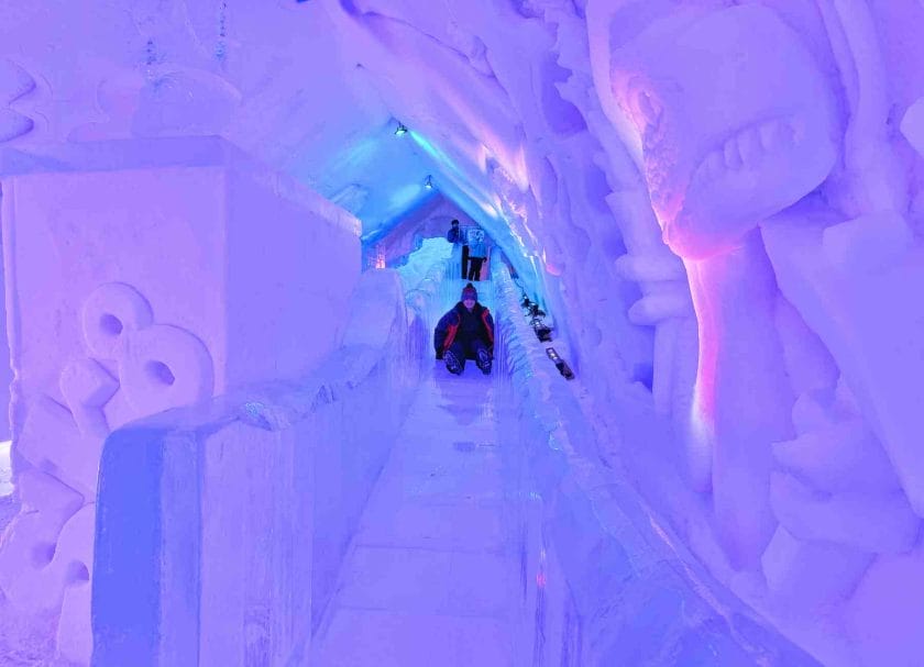 Carson glisse sur le toboggan de l'hôtel de glace.  Une chose incontournable à faire à Québec en hiver.