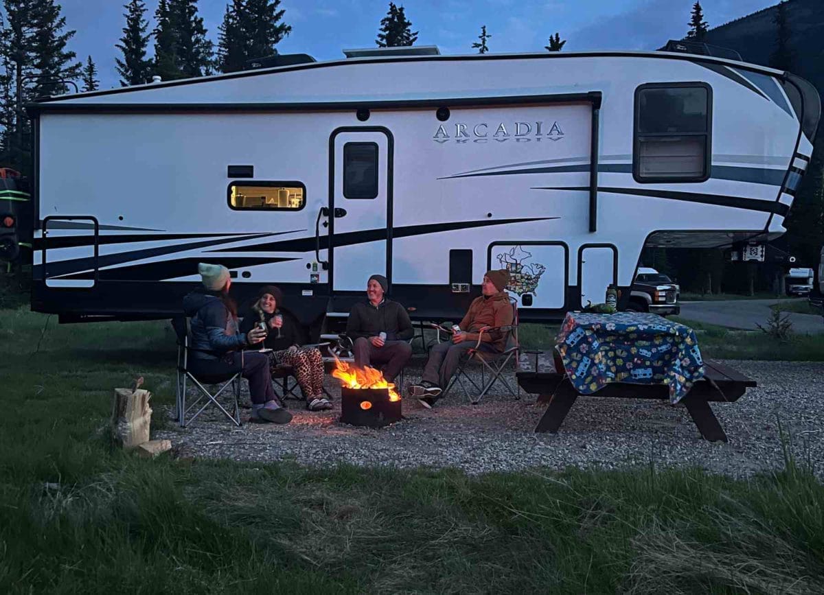 2 couples sitting in front of their Keystone Arcadia 5th wheel