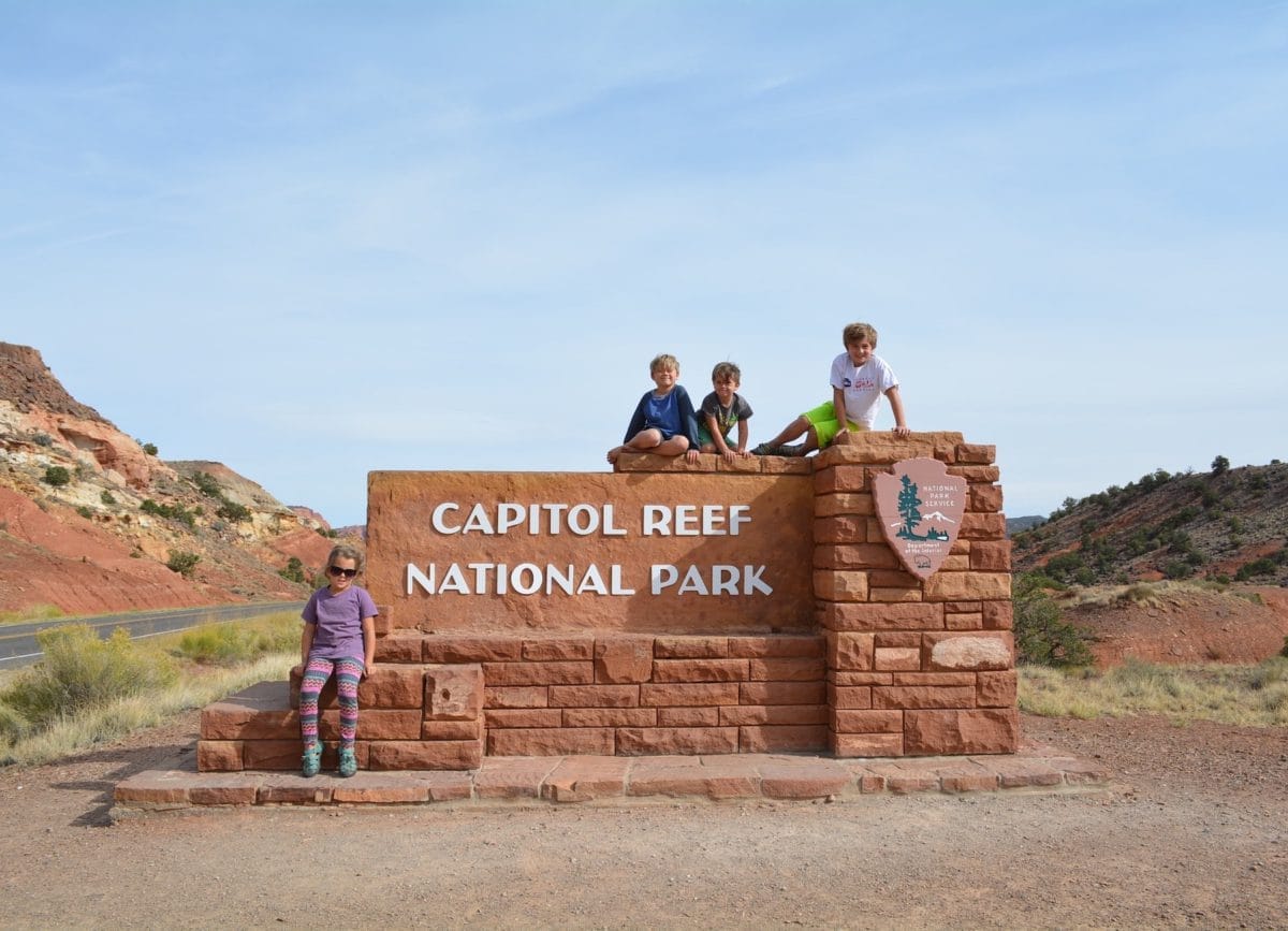 Kids sitting on Capitol Reef National Park sign