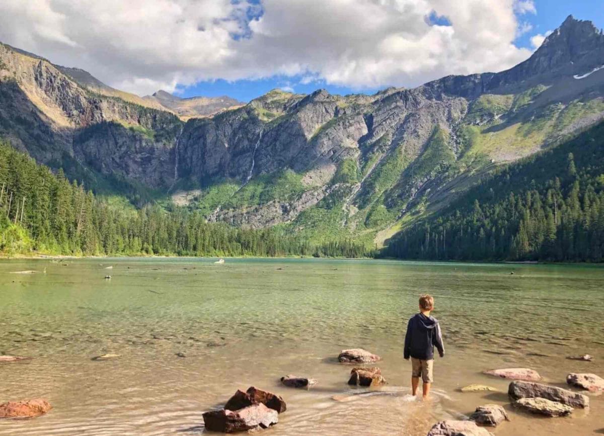 Picture of Knox standing and looking out at Avalanche Lake in Glacier National park