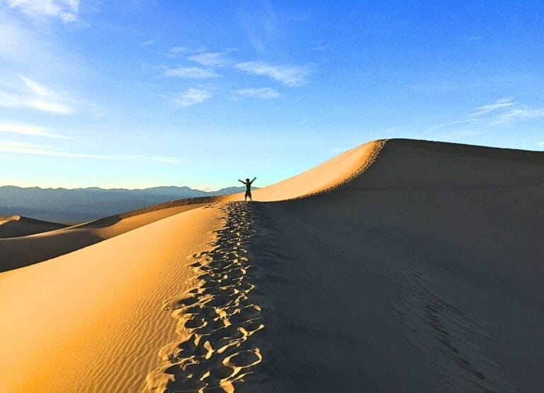 Kid on the sand dunes in Death Valley National Park. One of the top 9 National Parks to visit in November.